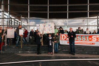 Crowd on Senedd steps with banners to Save the Gwent Levels